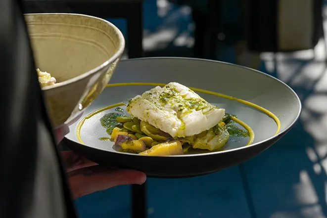 Photo d'un plat aux couleurs jaunes et grises : un poisson avec des légumes - restaurant Lac du Bourget - La Parfumerie